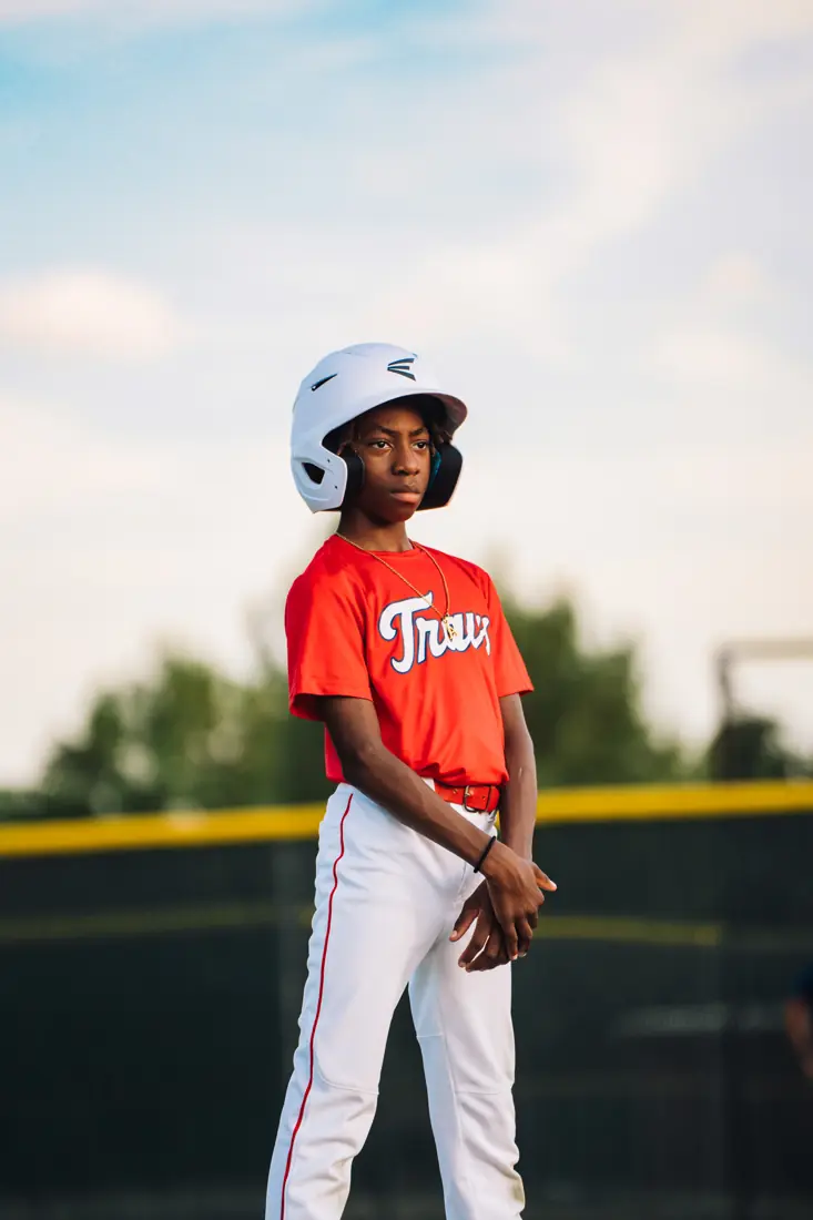 A Travelers player in a red jersey and white helmet on the field